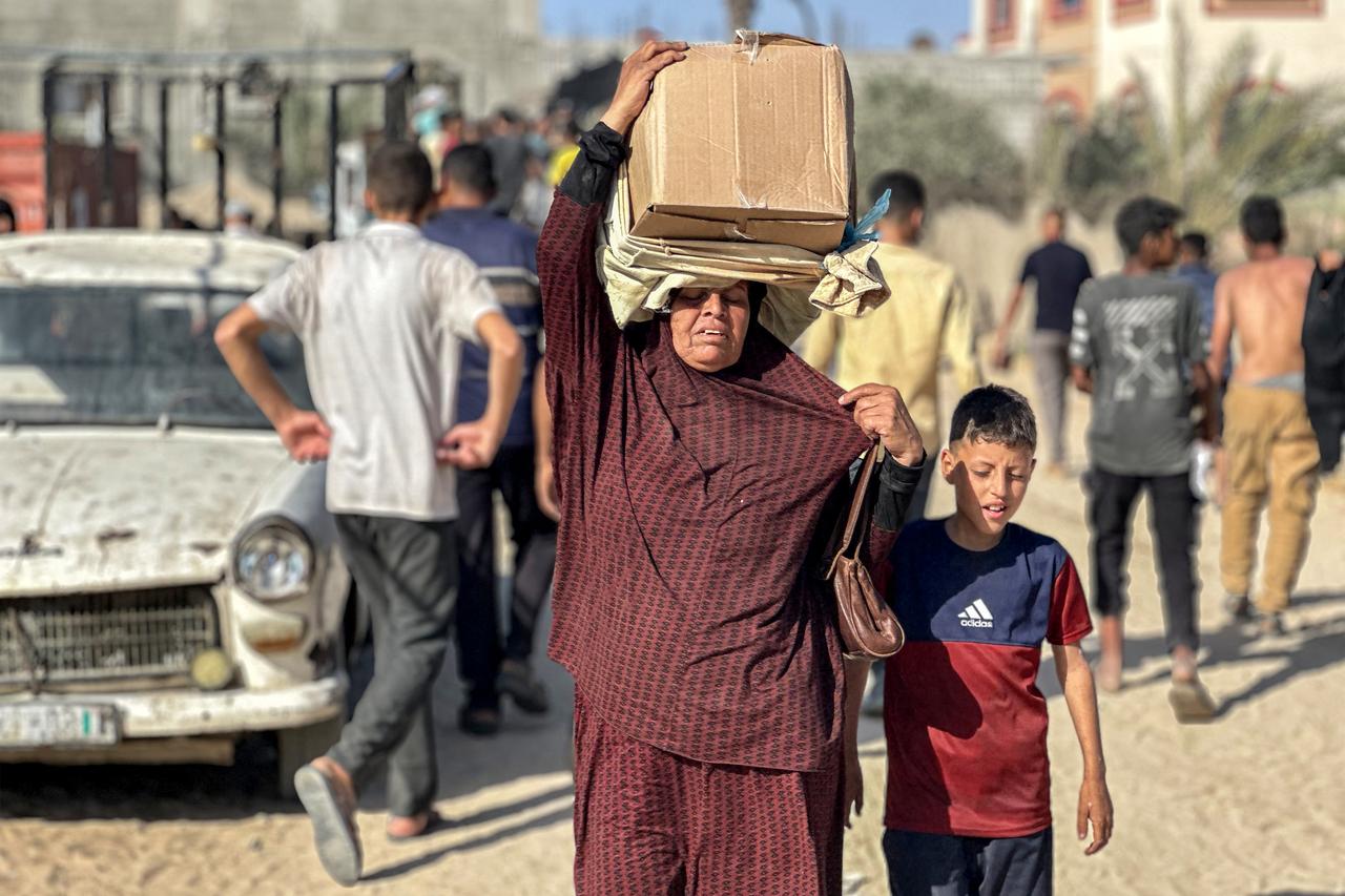 Displaced Palestinians receive food packages from a US-backed foundation pledging to distribute humanitarian aid in western Rafah in the southern Gaza Strip on May 27, 2025. Thousands of Palestinians rushed into a new aid distribution centre run by a US-backed group in southern Gaza on May 27, AFP journalists reported, leading to chaotic scenes as Israel implemented a new distribution system. The incident in Rafah came days after the partial easing of a total aid blockade on the territory that Israel imposed on March 2, leading to severe shortages of food and medicine. (Photo by AFP)
