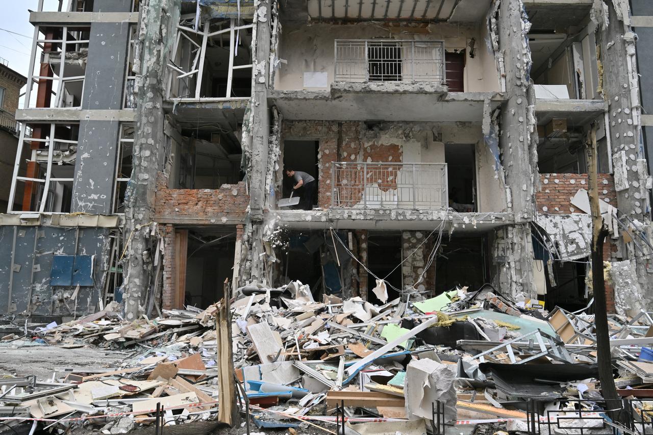 A local resident of a multistory residential building clears debris from his flat damaged following a drone strike in Kyiv on May 25, 2025, amid Russian invasion in Ukraine. Russia launched a record number of drones against Ukraine and killed 12 people across the country, officials said on May 25, even as Kyiv and Moscow completed their biggest prisoner exchange since the start of the war. (Photo by Sergei SUPINSKY / AFP)