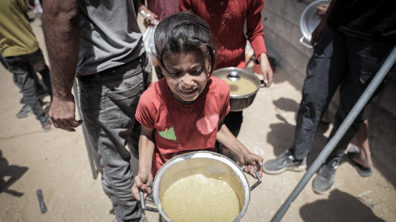 Displaced Palestinians line up in long queues to receive food distributed by aid organizations at Sheikh Radwan neighborhood in. Gaza City, Gaza on May 27, 2025. (AA Photo)