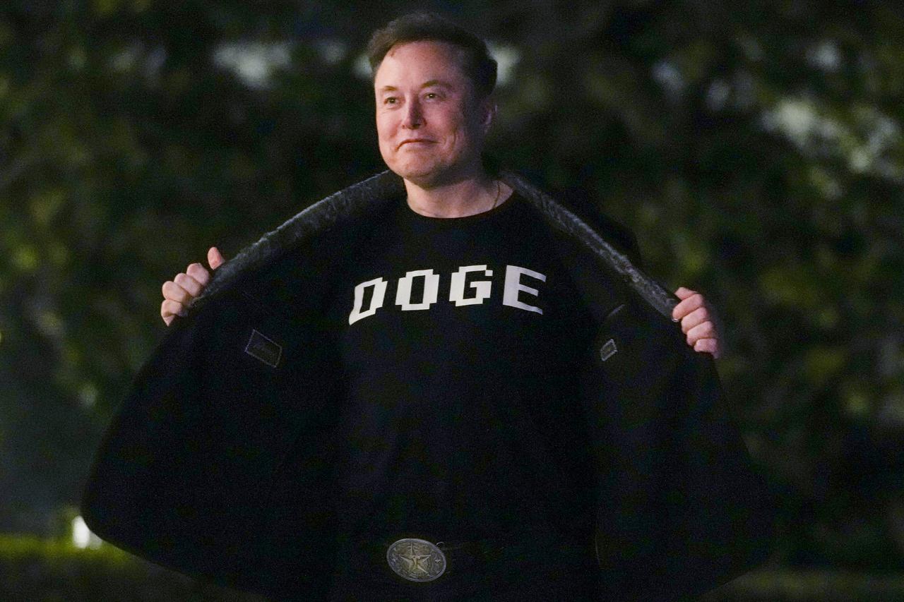 Elon Musk shows off a shirt that says  DOGE  as he walks on the South Lawn of the white House after stepping off Marine One upon arrival to the White House in Washington, DC on March 9, 2025. (AFP Photo)