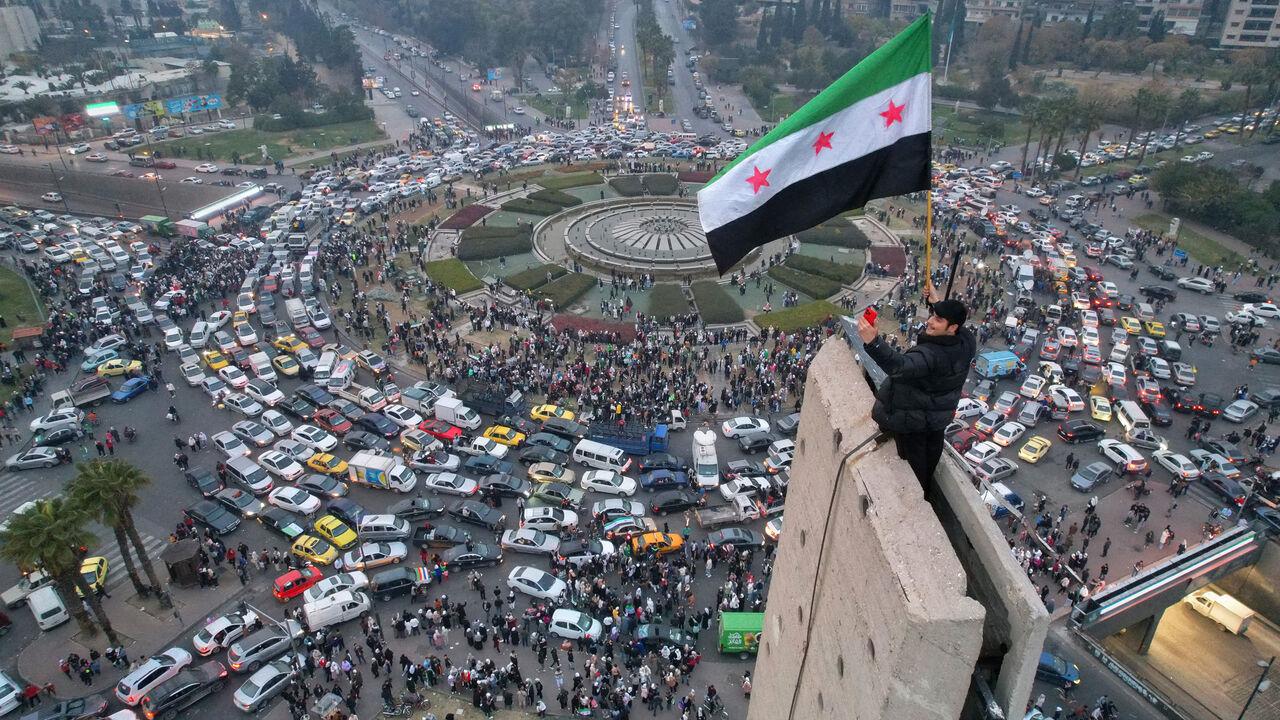 An aerial view shows a Syrian man waving the independence-era Syrian flag at Damascus central Umayyad Square on Dec. 11, 2024 (AFP Photo)