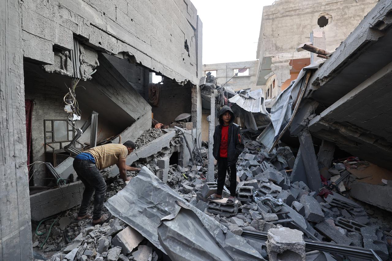 Palestinian children stand over empty containers at a food distribution centre in the Nuseirat camp for refugees, in the central Gaza Strip, on April 30, 2025. (AFP Photo)