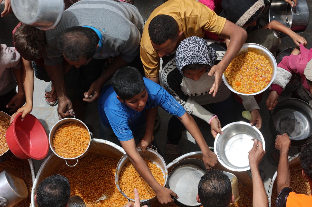 Palestinians queue for a hot meal at a charity kitchen in Gaza City on April 30, 2025. The UN food agency, one of the main providers of food assistance in the besieged Palestinian territory said on April 25 it had 