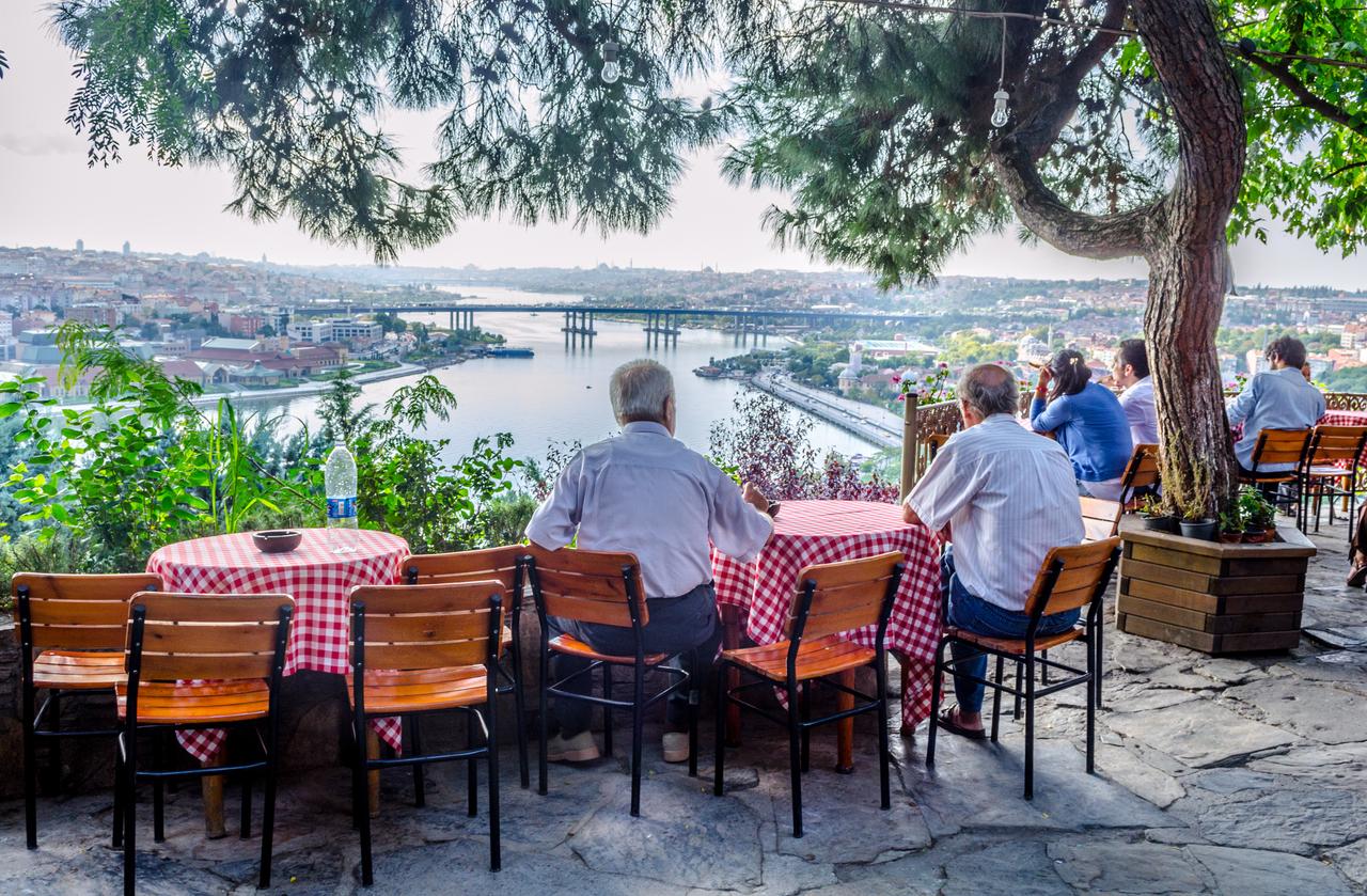 People sit at a cafe overlooking the Golden Horn in Istanbul, Türkiye, accessed on May 30, 2025. (Adobe Stock Photo)