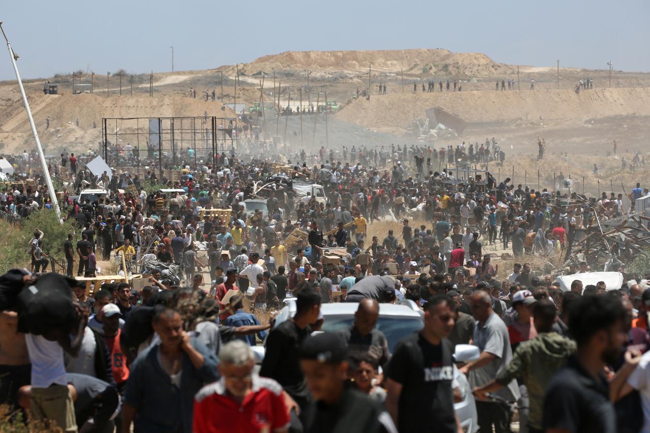 Displaced Palestinians carrying relief supplies return from an aid distribution centre in the central Gaza Strip on May 29, 2025. The humanitarian situation in Gaza, where aid has finally begun to trickle in after a two-month blockade, is dire following 18 months of devastating war between Israel and Palestinian Hamas movement. Food security experts say starvation is looming for one in five people. (Photo by Eyad BABA / AFP)