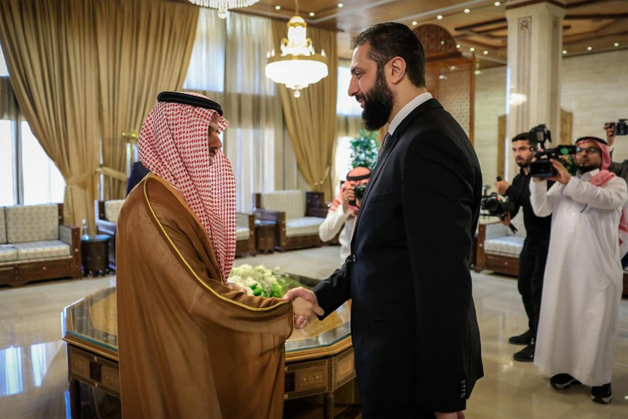 Syrias interim president Ahmed al-Sharaa (R) receiving Saudi Arabias Foreign Minister Prince Faisal bin Farhan (L) in Damascus on May 31, 2025.  (SANA via AFP)