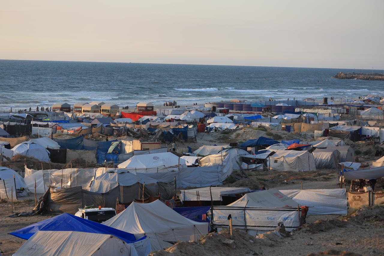 GAZA CITY, GAZA - MAY 30: Displaced Palestinians continue to migrate south on foot via Al-Rashid road as Palestinians, who live in makeshift tents set up on the shore, continue their lives under difficult conditions in the Gaza Strip, where Israel continues its attacks, on May 30, 2025.  ( Dawoud Abo Alkas - Anadolu Agency )