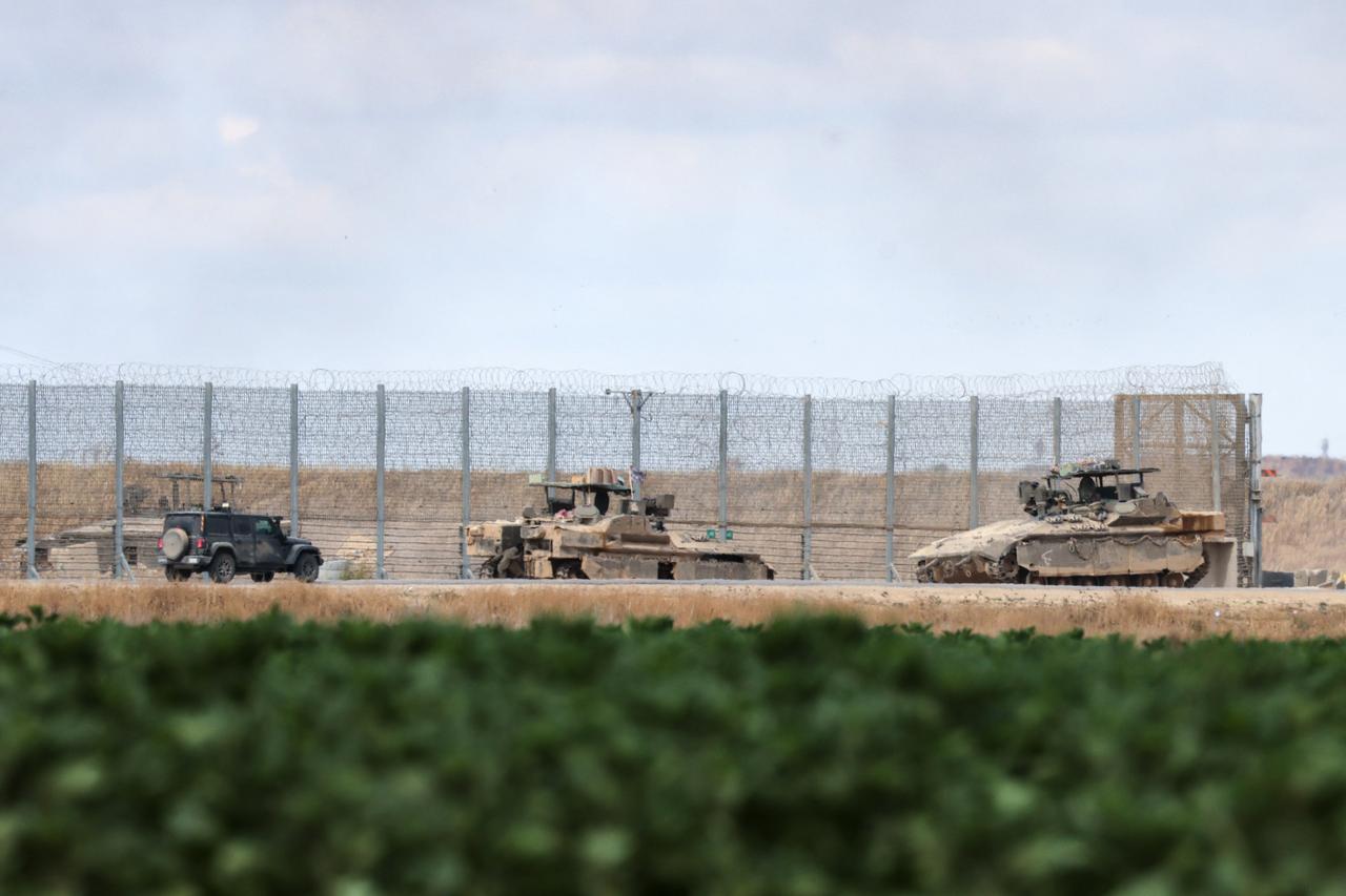 An Israeli soldier walks near tanks deployed at a position near Israels border with the Gaza Srip on May 4, 2025. Israel was issuing orders to call up tens of thousands of reservists ahead of an expanded offensive in Gaza, Israeli media reported on May 3, as Prime Minister Benjamin Netanyahu attacked truce mediator Qatar. (Photo by Menahem KAHANA / AFP)