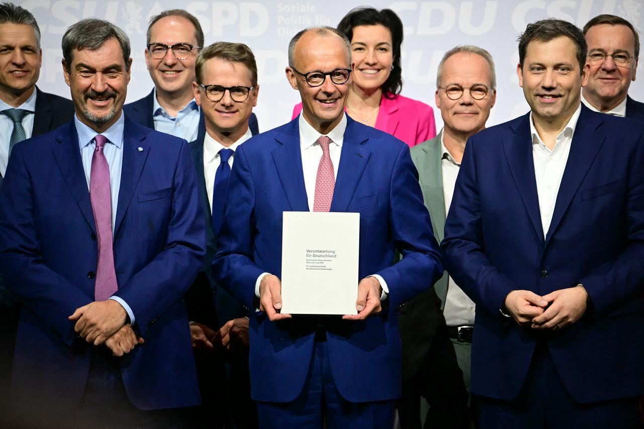 The leader of Germanys conservative Christian Democratic Union (CDU) party Friedrich Merz (C), the co-chairman of Germanys Social Democratic Party (SPD) Lars Klingbeil (C-R) and the leader of Bavarias conservative Christian Social Union (CSU) party Markus Soeder (C-L) pose with members of the new cabinet and party officials after signing a coalition deal to form the countrys new government in Berlin, Germany on May 5, 2025. (AFP Photo)