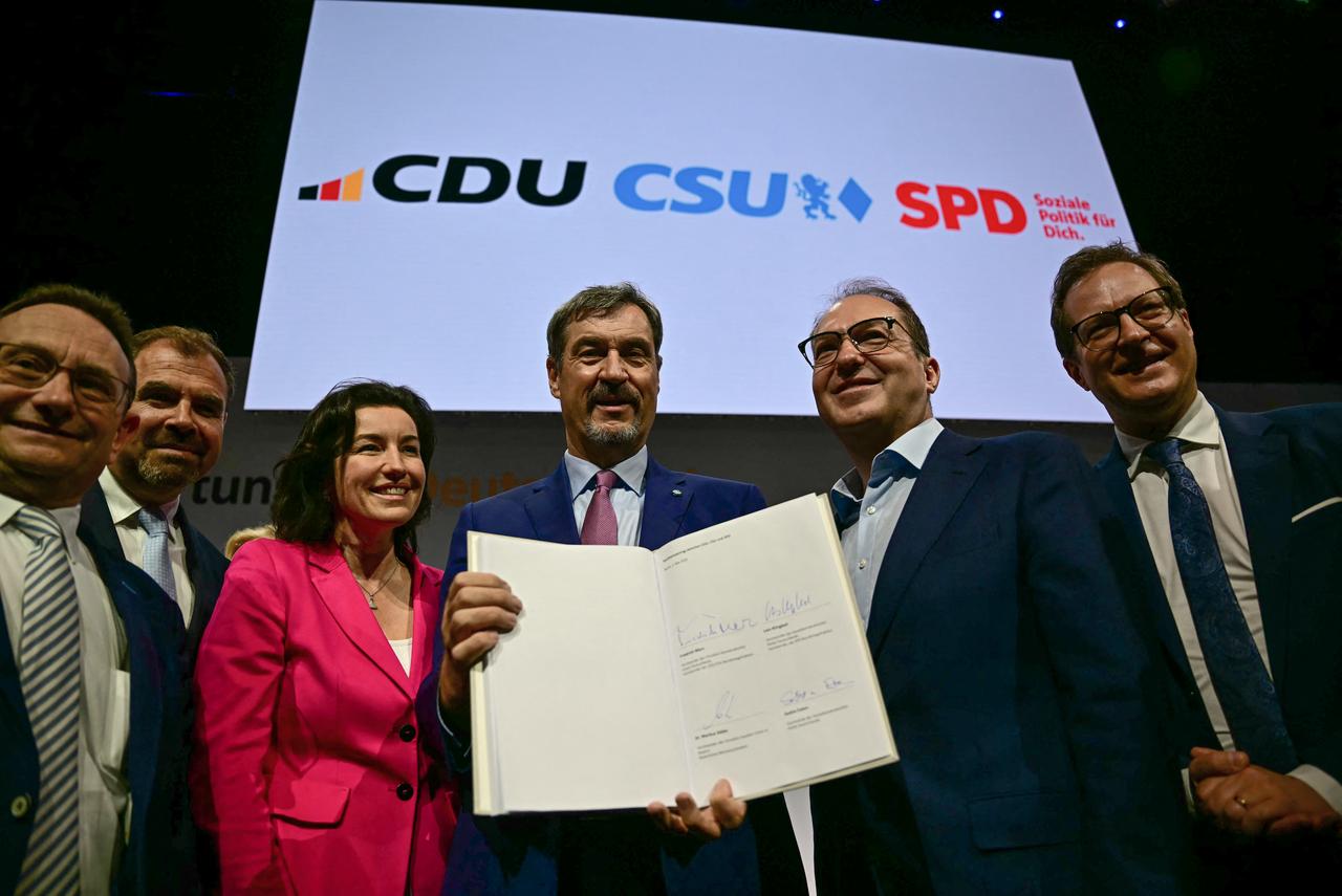 Bavaria's State Premier and leader of the conservative Christian Social Union (CSU) Markus Soeder (C) together with designated German Minister for Research, Technology and Space Dorothee Baer (3L), designated German Interior Minister Alexander Dobrindt (2R) and others poses with a copy of the coalition agreement between Germany's Christian Democratic Union (CDU) party, the Christian Social Union (CSU) and the Social Democratic Party (SPD) to form the country's new government during a press conference after it was signed by CDU leader Friedrich Merz, Co-Chairs of the SPD Lars Klingbeil and Saskia Esken and Bavaria's State Premier and CSU leader Markus Soeder in Berlin on May 5, 2025. (AFP Photo)