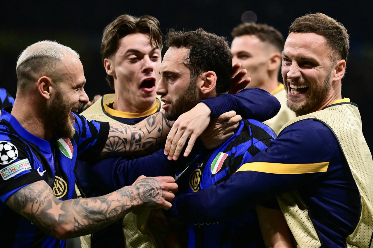 Inter Milans Turkish midfielder #20 Hakan Calhanoglu (C)celebrates scoring his teams second goal with teammates during the UEFA Champions League semi-final second leg football match between Inter Milan and FC Barcelona at the San Siro stadium in Milan, Italy on May 6, 2025. (AFP Photo)