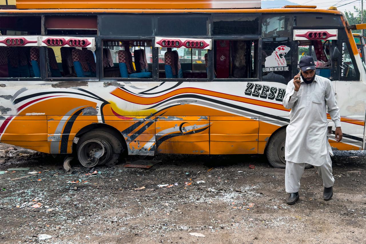 A man walks past a damaged bus in the Indian-run town of Poonch on May 8, 2025. (AFP Photo)