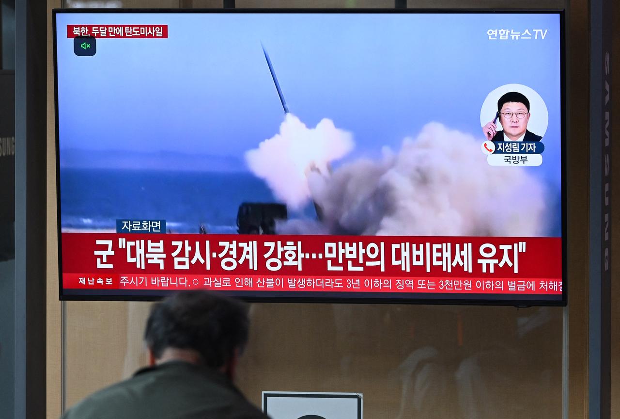 A man watches a television screen showing a news broadcast with file footage of a North Korean missile test, at a train station in Seoul on May 8, 2025. (AFP Photo)