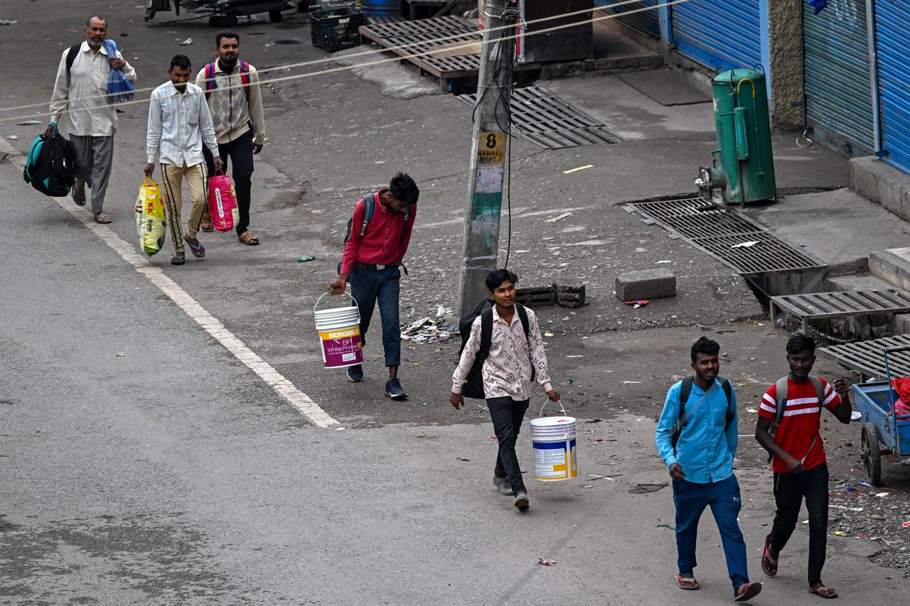 People carry their belongings along a deserted road as they try to leave the town of Poonch on May 9, 2025. (AFP Photo)