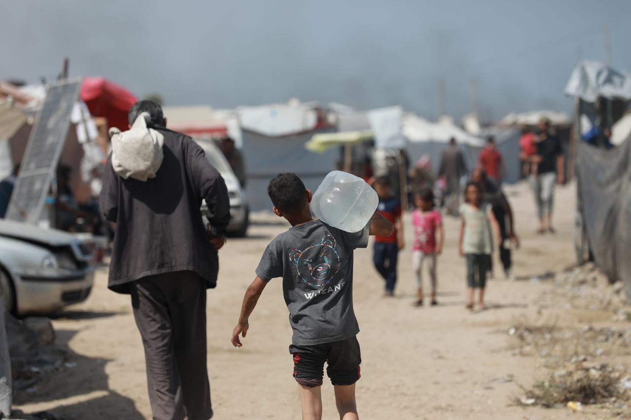 GAZA CITY, GAZA - JUNE 01: Palestinians, including children in western Gaza City carry filled containers with water distributed by a water tanker, amid ongoing Israeli attacks and the continued closure of border crossings, which have severely limited access to clean water in the Gaza Strip on June 01, 2025. ( Abdul Hakim Abu Riash - Anadolu Agency )