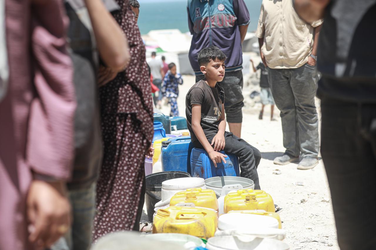 GAZA CITY, GAZA - MAY 31: Palestinians, including children in western Gaza City wait in line to fill containers with water distributed by a water tanker, amid ongoing Israeli attacks and the continued closure of border crossings, which have severely limited access to clean water in the Gaza Strip on May 31, 2025. ( Abdul Hakim Abu Riash - Anadolu Agency )