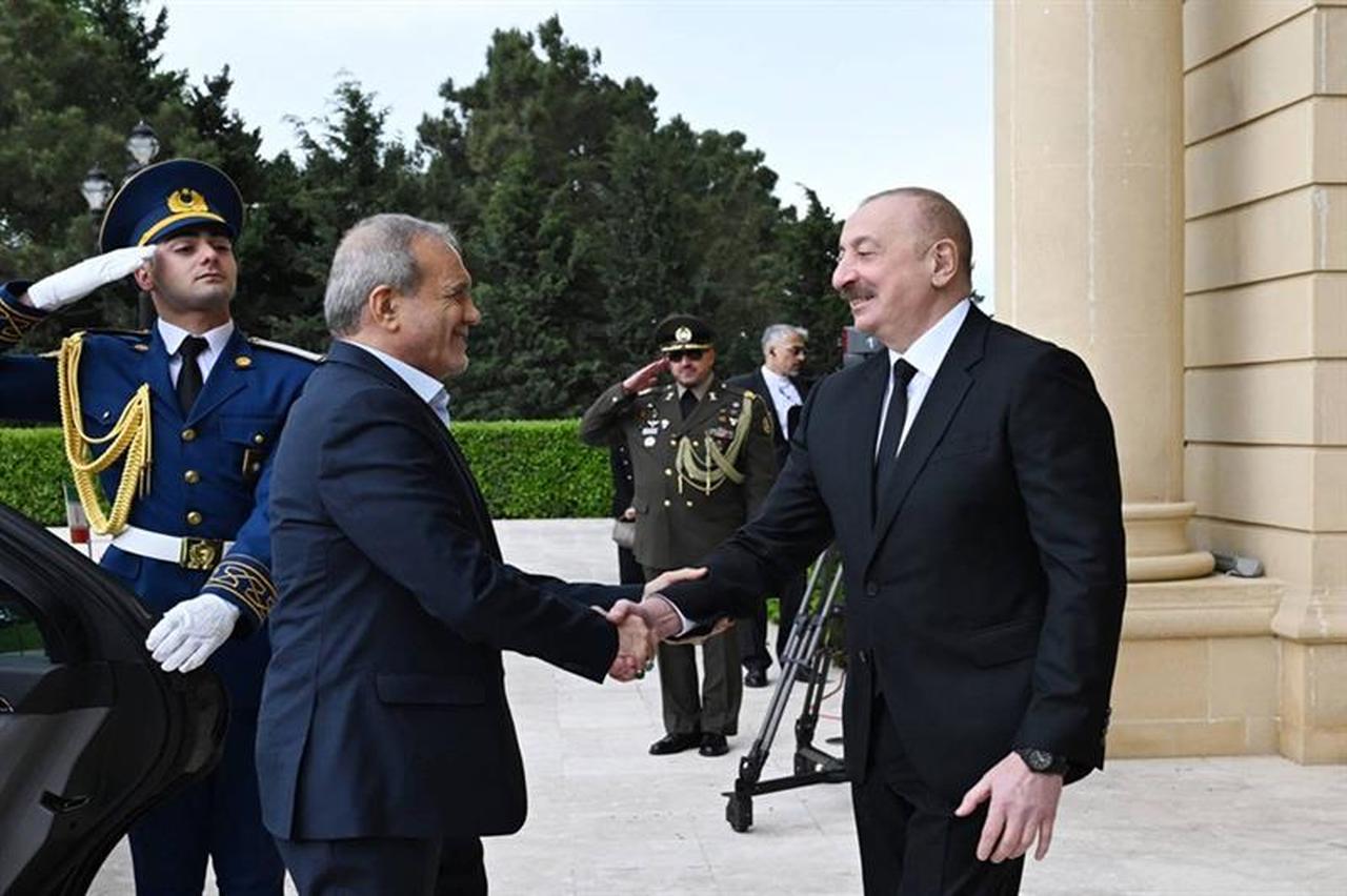 In this handout picture taken and released by the Azerbaijani presidency on April 28, 2025, Azeri President Ilham Aliyev and his Iranian counterpart Masoud Pezeshkian attend a welcoming ceremony prior to their talks in Baku. (Photo by Handout / Azerbaijani presidency / AFP)