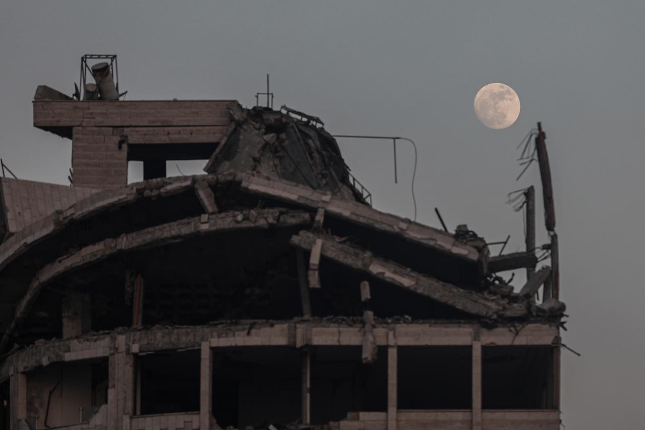 A full moon rises over a heavily damaged building in Gaza City amid ongoing Israeli attacks on Gaza on June 09, 2025. (AA Photo)