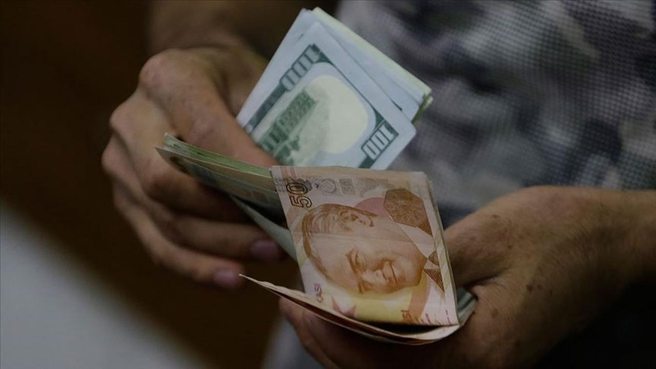 File photo shows a man counting Turkish lira and US dollar bills in an exchange bureau in Istanbul, Turkey. The photograph was accessed on 10 June 2025. (AA Photo)