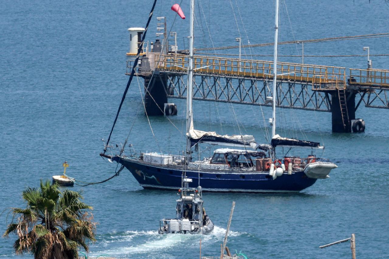 An Israeli police patrol boat moves near the aid sailboat Madleen as it is moored at the southern port of Ashdod on June 10, 2025 after being intercepted the previous day by Israeli forces. (AFP Photo)