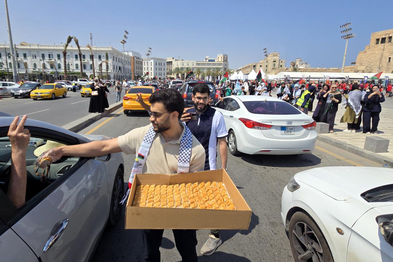 Activists, heading towards Gaza by land with the aim of breaking the siege on the Palestinian territory, are greeted by Libyans in Tripolis Martyrs Square on June 11, 2025. (AFP Photo)