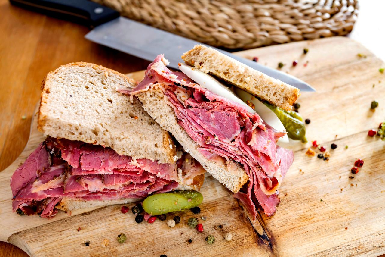 Pastrami sandwich on wooden board. (Adobe Stock Photo)