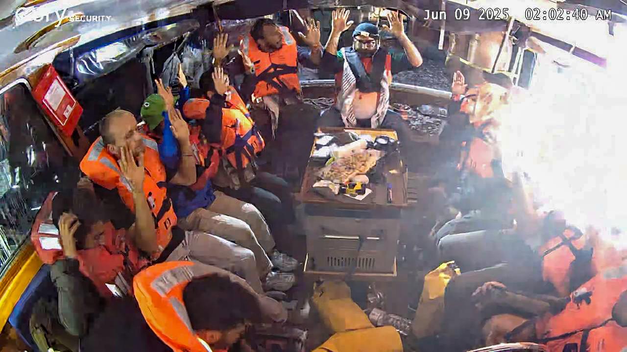 Photo shows activists raising their hands after Israeli soldiers board the Madleen aid ship bound for Gaza, accessed on June 11, 2025. (AA Photo)