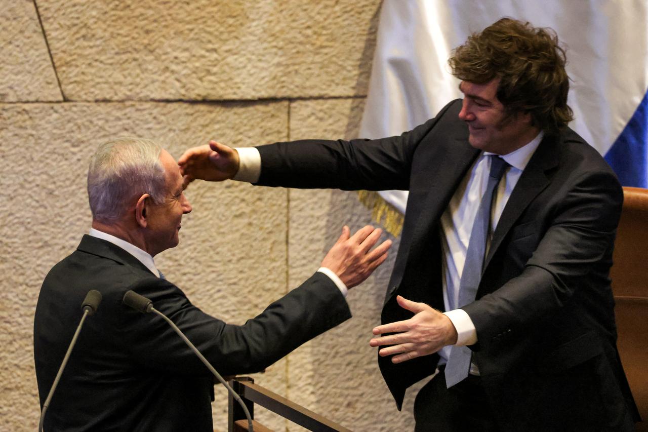 Argentinas President Javier Milei (R) embraces Israels Prime Minister Benjamin Netanyahu (L) after the latters address to the assembly during a session of the Israeli parliament (Knesset) at its headquarters in Jerusalem on June 11, 2025. (Photo by Menahem KAHANA / AFP)