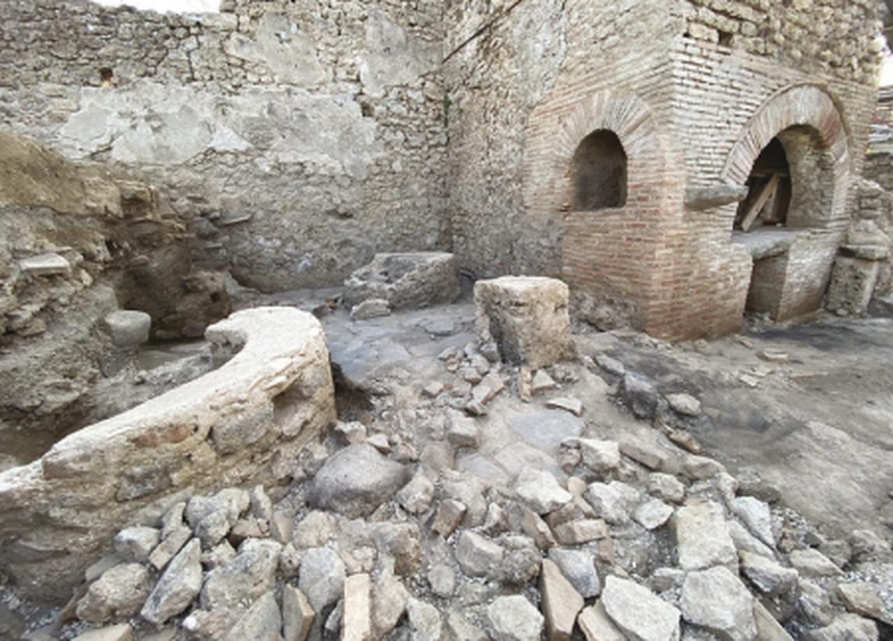 The productive spaces of the bakery in Regio IX showing the bread oven and the bare furnishings. (Photo via Parco Archeologico di Pompei)