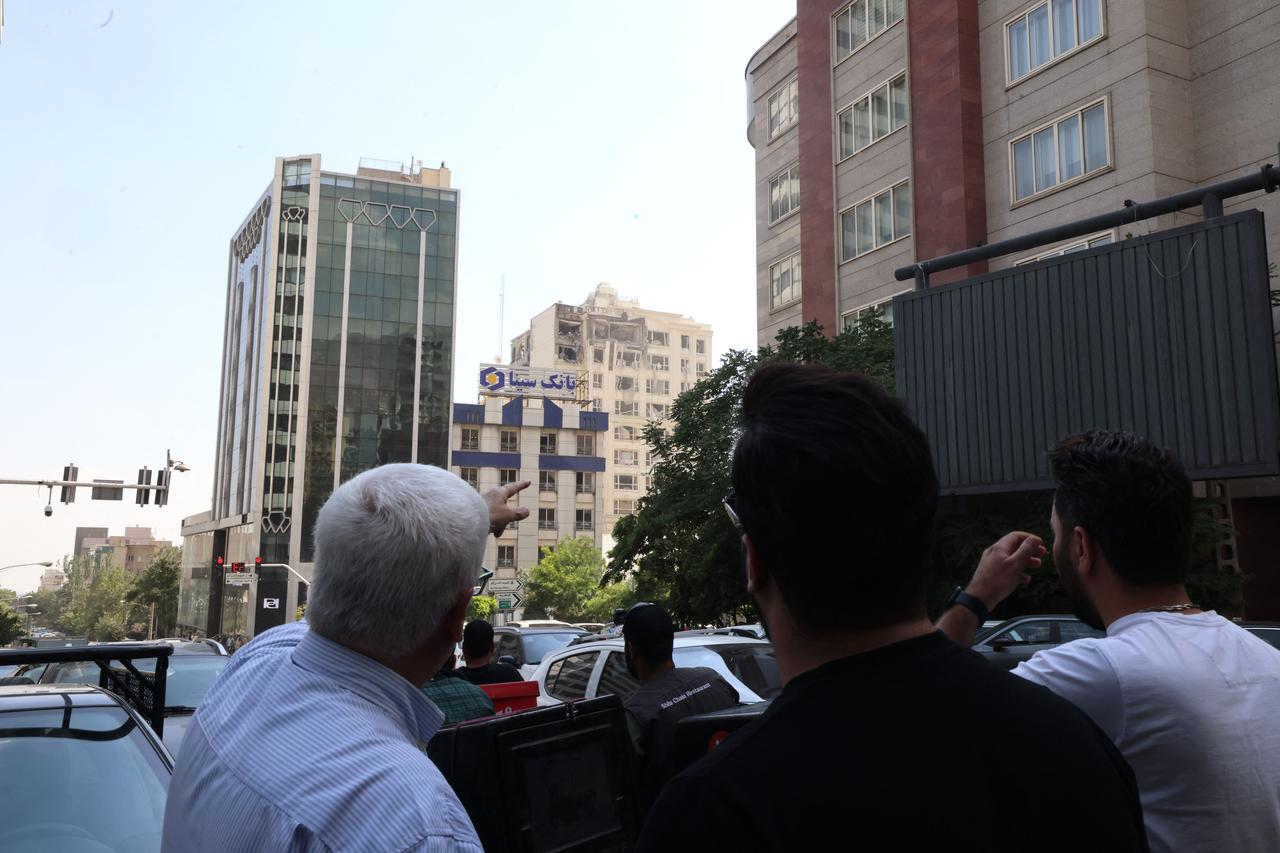 Onlookers gather in front of a building damaged in an Israeli strike on Tehran, Iran on June 13, 2025. (AFP Photo)