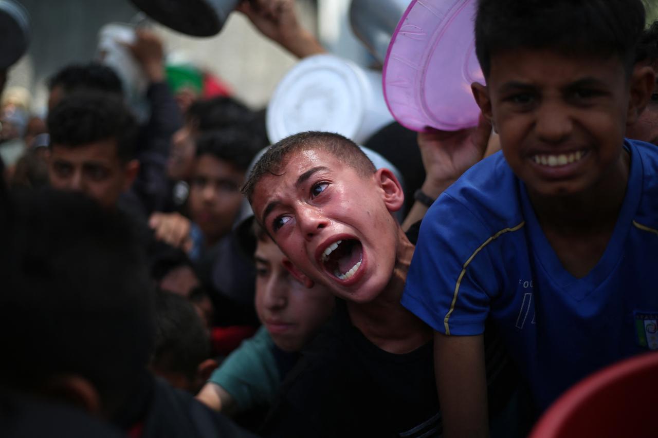 Palestinian children wait for food at a distribution point in Nuseirat, in the central Gaza Strip, on June 11, 2025. (AFP Photo)
