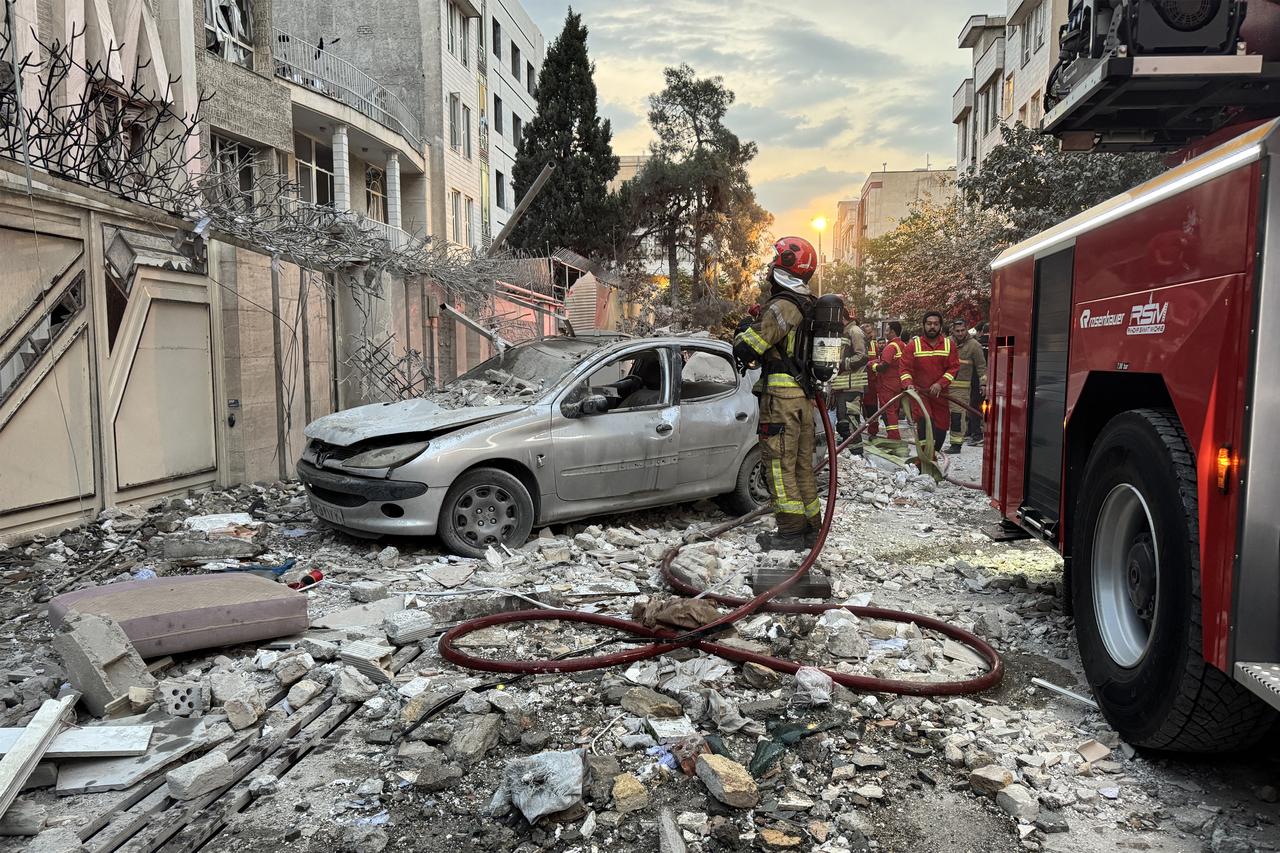 First-responders gather outside a building that was hit by an Israeli strike in Tehran on June 13, 2025. Israel hit about 100 targets in Iran on June 13, including nuclear facilities and military command centres and killing senior figures including the armed forces chief and top nuclear scientists. (Photo by MEGHDAD MADADI / TASNIM NEWS / AFP)