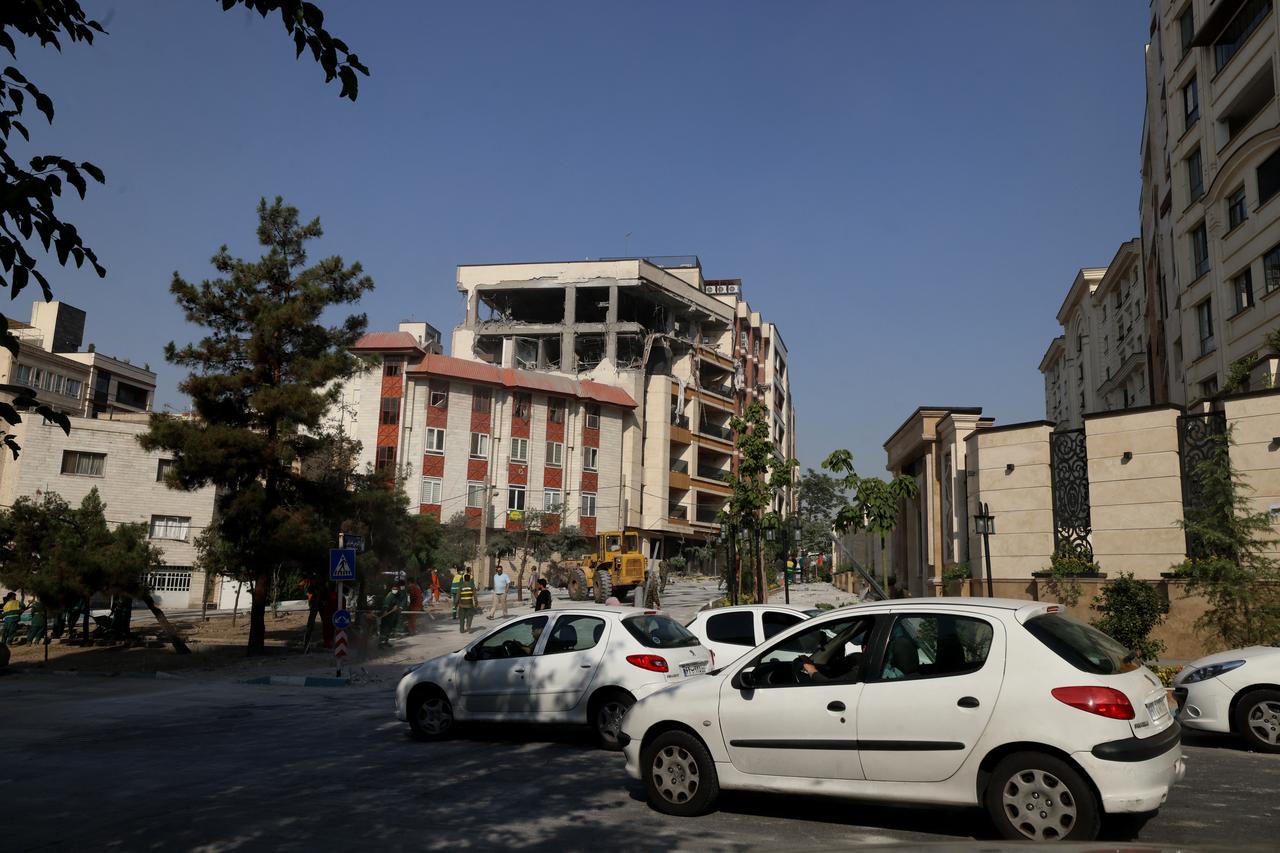 Motorists pass a damaged building after it was targeted by an Israeli strike in the Iranian capital Tehran, on June 13, 2025. (AFP Photo)