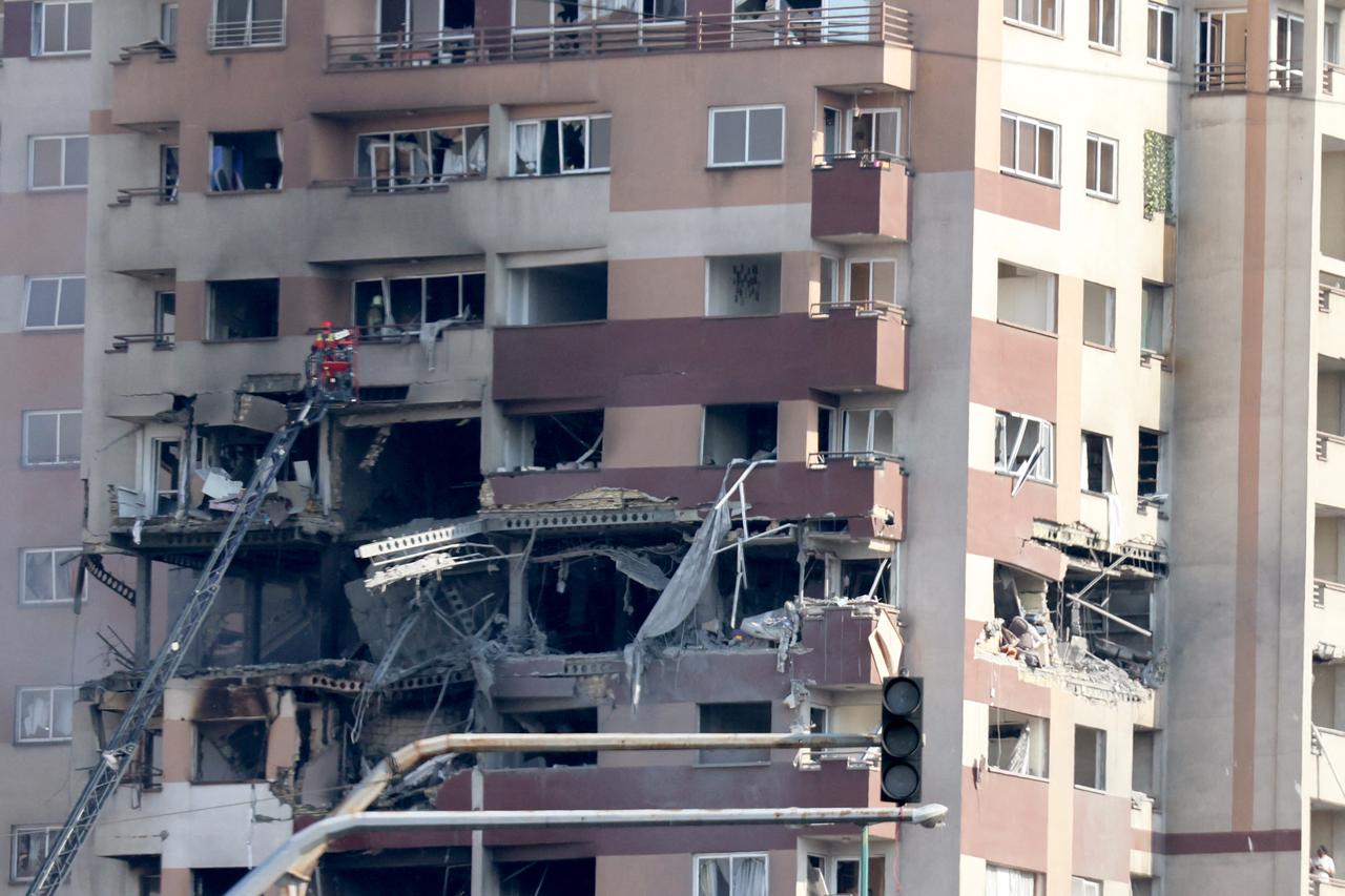 Rescue teams work outside a building targeted by an Israeli strike in the Iranian capital Tehran on June 13, 2025. Israel carried out strikes against Iran early on June 13, targeting its nuclear and military sites as well as residential buildings in Tehran, after US President Donald Trump warned of a possible  massive conflict  in the region. (Photo by ATTA KENARE / AFP)