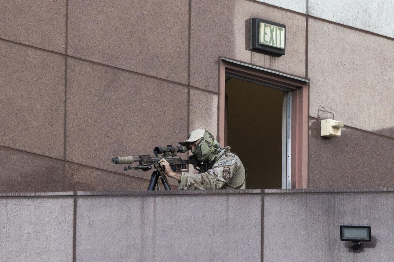 An Immigration and Customs Enforcement (ICE) Special Response Team (SRT) sniper looks through his scope as protests continue in response to federal immigration operations at the Metropolitan Detention Center in Los Angeles on June 13, 2025. (AFP Photo)