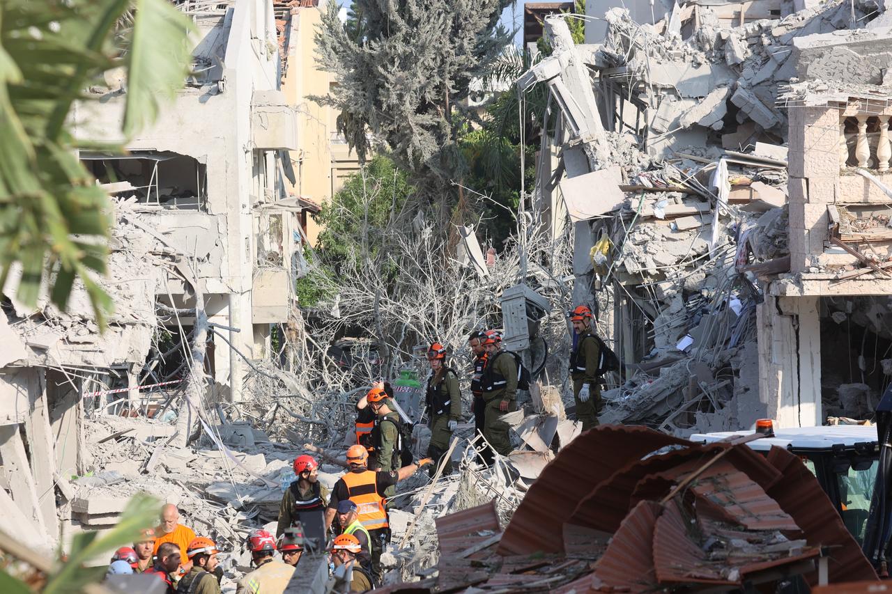 Israeli emergency responders inspect a site hit by a missile fired from Iran near Tel Aviv on June 14, 2025. (AFP Photo)