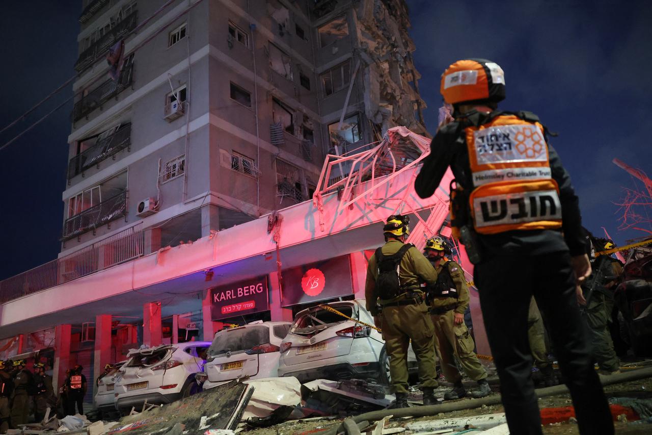 Responders work beside a damaged building following a strike by an Iranian missile in the Israeli city of Bat Yam, south of Tel Aviv, early on June 15, 2025. (AFP Photo)