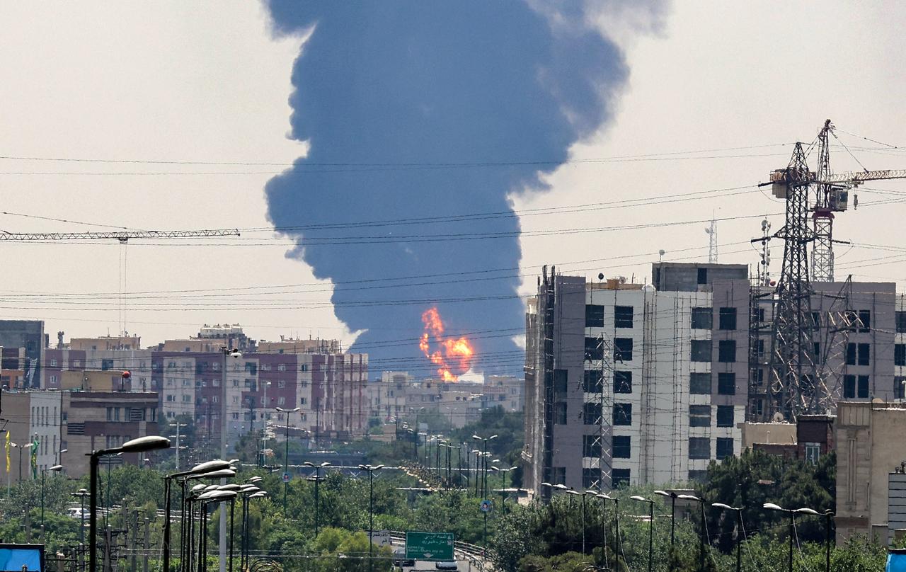 A plume of heavy smoke and fire rise over an oil refinery in southern Tehran, after it was hit in an overnight Israeli strike, on June 15, 2025. Iran fired a fresh barrage of missiles at Israel, state television announced early on June 15, as the rivals exchanged fire for a third day. (Photo by ATTA KENARE / AFP)