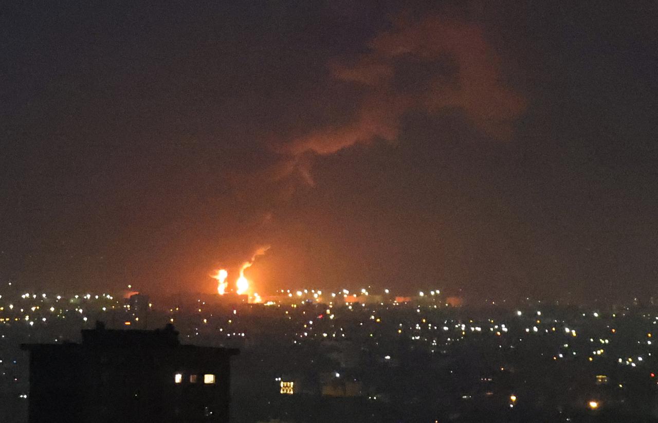 Flames from a fire at the Tehran oil refinery, located south of the capital, are seen burning in the distance on June 15, 2025. (AFP Photo)