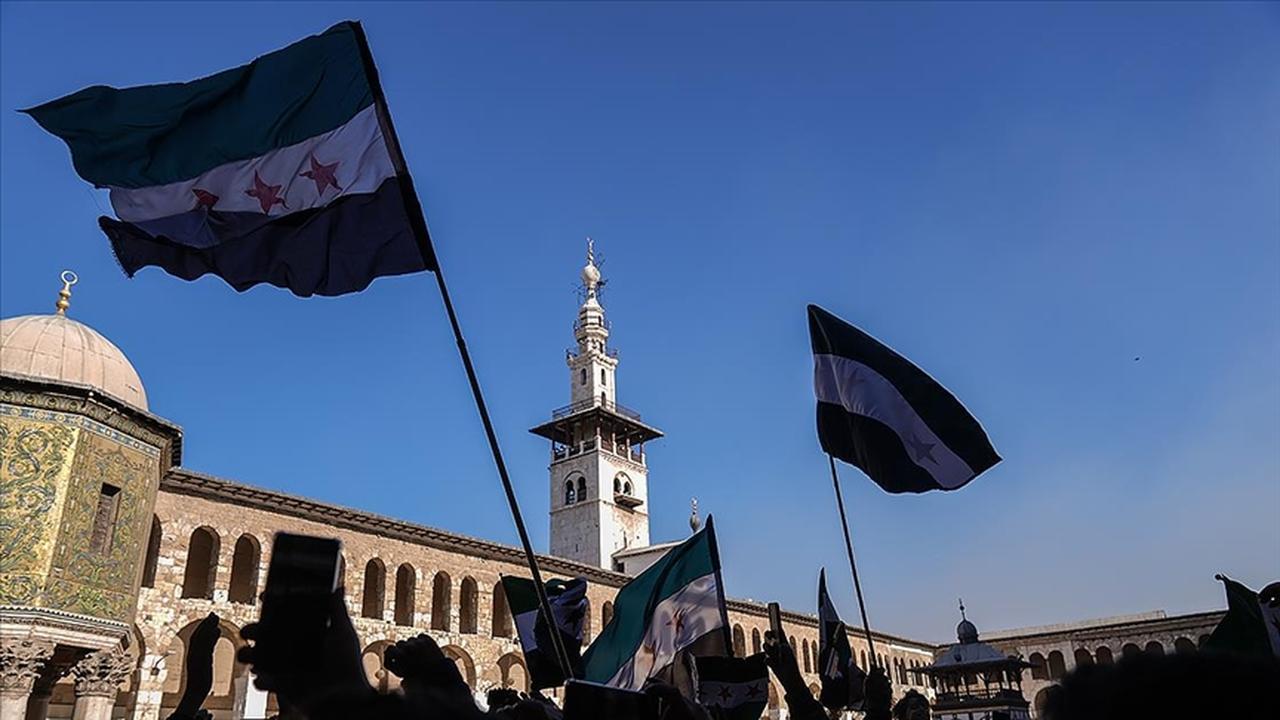 People wave Syrian opposition flags during a demonstration in front of the Umayyad Mosque in Damascus, Syria, accessed on June 16, 2025. (AA Photo)