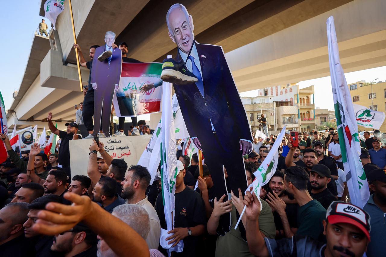 Supporters of Iraqi pro-Iran groups hold a cutout of US President Donald Trump and Israeli PM Benjamin Netanyahu during a protest in support of Iran, near a bridge leading to the green zone in Baghdad, Iraq on June 16, 2025. (AFP Photo)
