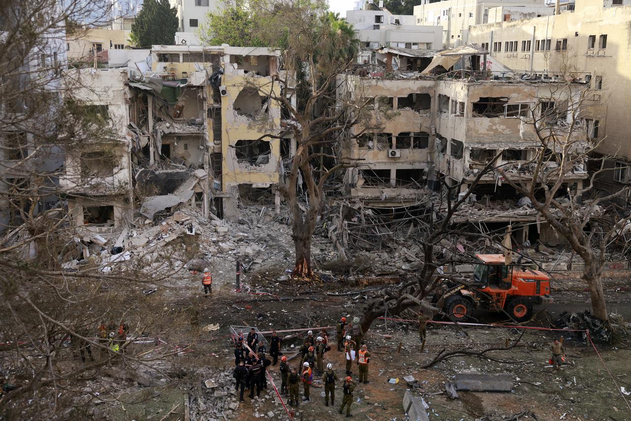 Rescuers stand amid the debris of damaged building in the Israeli city of Tel Aviv following an Iranian missile attack on June 16, 2025. (AFP Photo)
