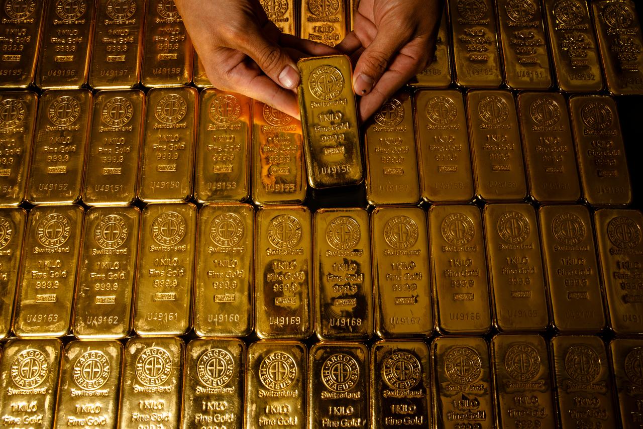 File photo shows a worker handling a 1-kilogram gold bar at a precious metals facility, accessed on June 17, 2025. (Adobe Stock Photo)