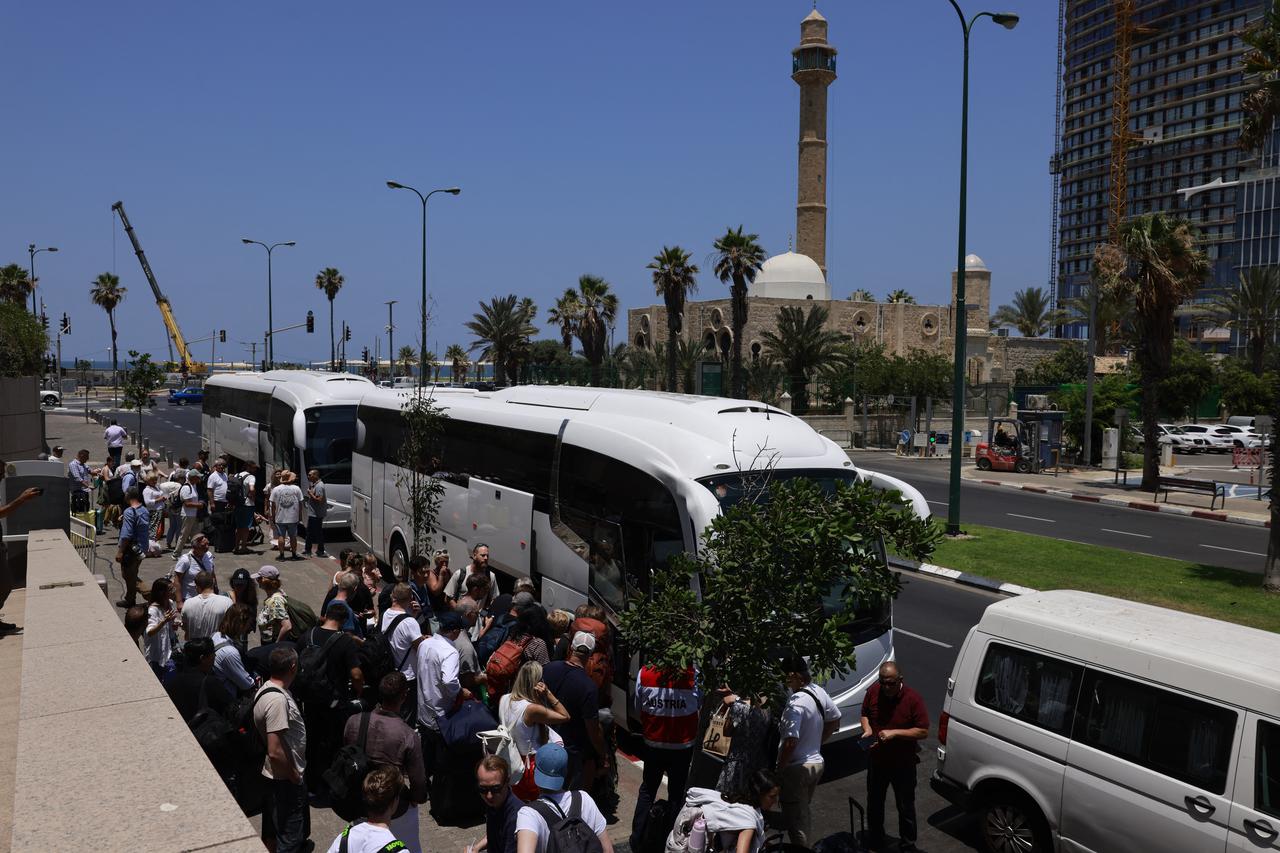 People arrive with their luggage before the departure of buses slated to evacuate foreign passport holders, mainly European and Polish, out of Israel, at a meeting point in Tel Aviv on June 17, 2025. (AFP Photo)