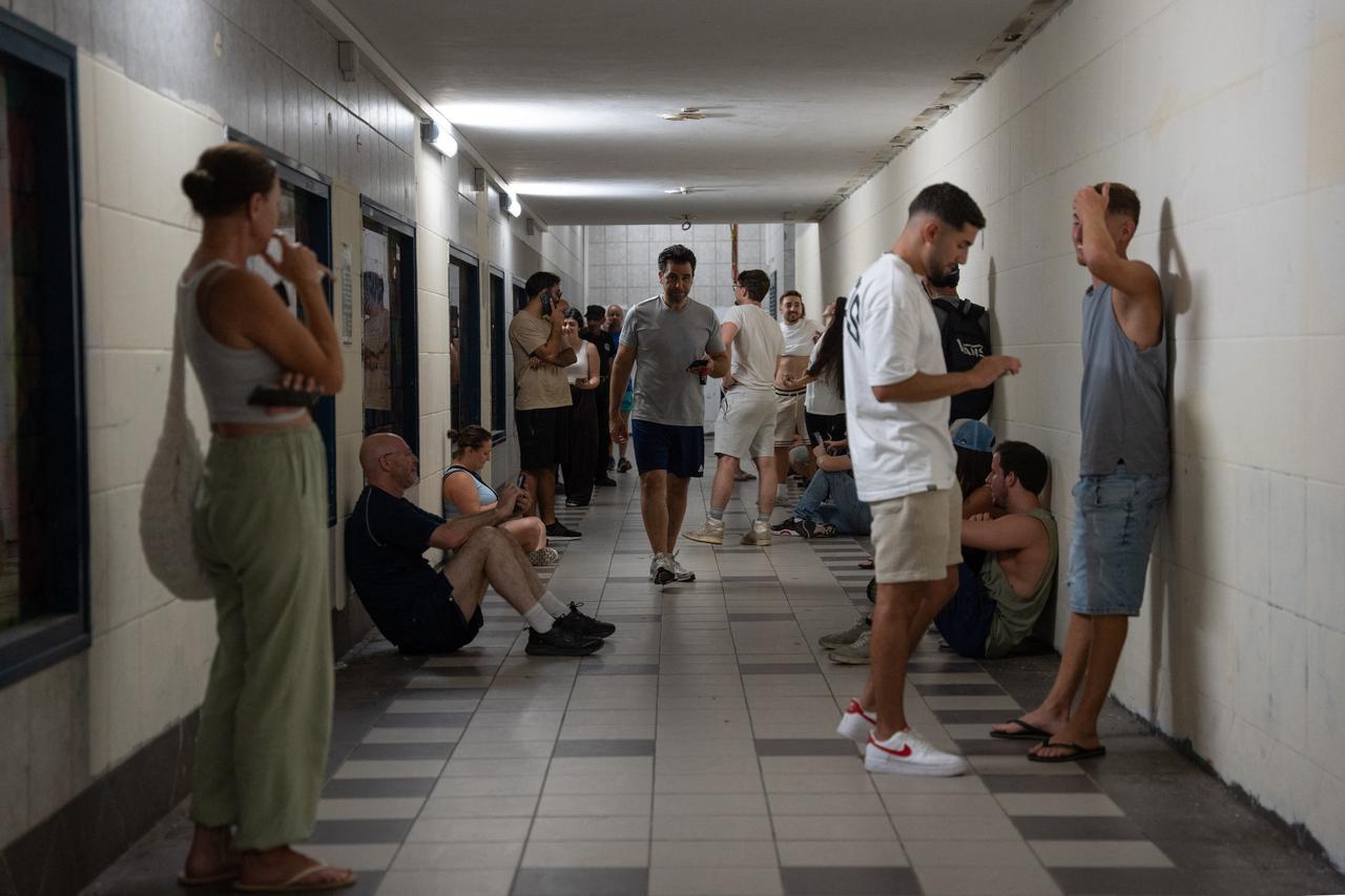 Israelis take shelter during a missile siren alert in Haifa, on June 16, 2025. Israel and Iran traded deadly fire for a fourth day on June 16 in their most intense confrontation in history, fuelling fears of a drawn-out conflict that could engulf the Middle East. (Photo by Maya Levin / AFP)