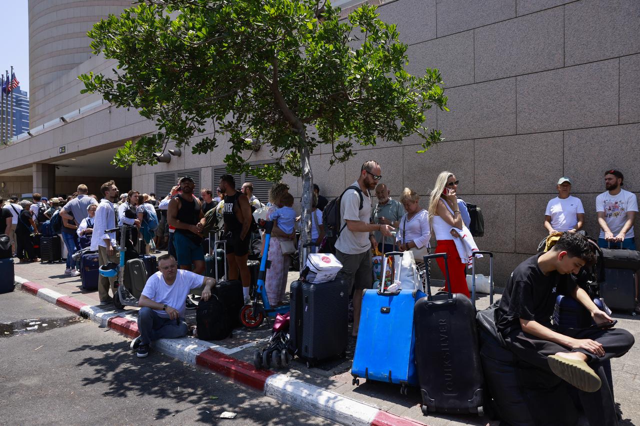 People arrive with their luggage before the departure of buses slated to evacuate foreign passport holders, mainly European and Polish, out of Israel, at a meeting point in Tel Aviv on June 17, 2025. (AFP Photo)