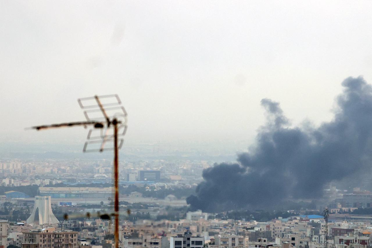 Smoke billows from an explosion near the Azadi Tower (L) in Tehran on June 16, 2025. (AFP Photo)