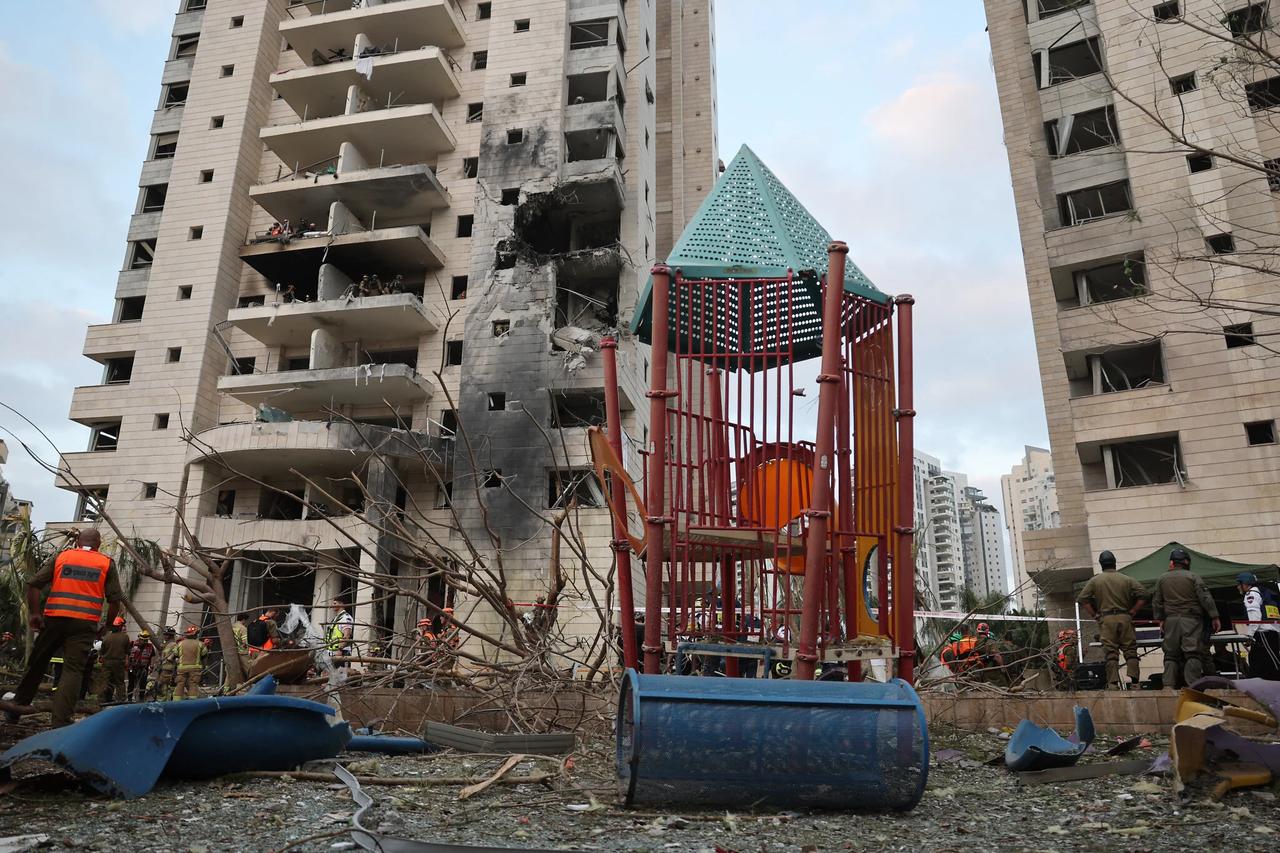 Responders are seen next to a damaged building following a strike by an Iranian missile in the Israeli city of Petah Tikva, east of Tel Aviv, on June 16, 2025. (AFP Photo)