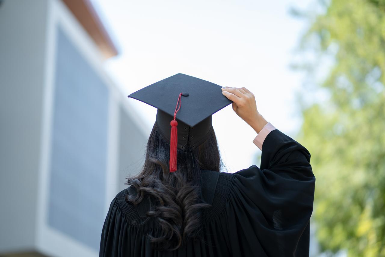 The student is ready to throw her graduation cap. (Adobe Stock Photo)