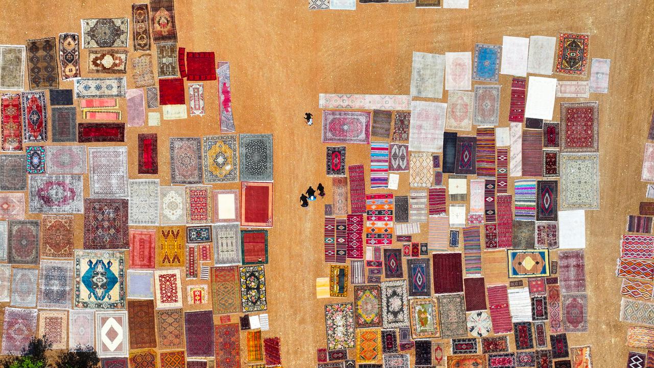 An aerial view shows handwoven carpets laid out in the open fields of Dosemealti district in Antalya, Türkiye, to naturally soften their colors under the sun, on June 18, 2025. (AA Photo)